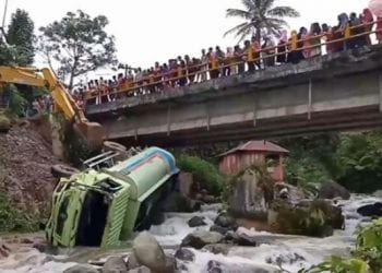 Warga menyaksikan truk CPO yang terjun ke sungai di Madina.