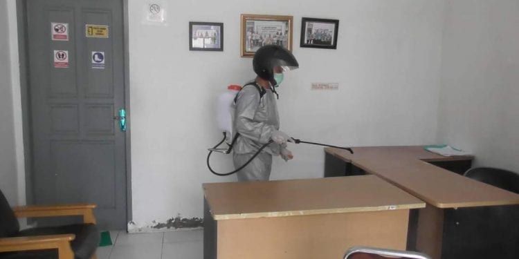 Petugas saat menyemprotkan desinfektan di salah satu ruang kantor DLH Labuhanbatu