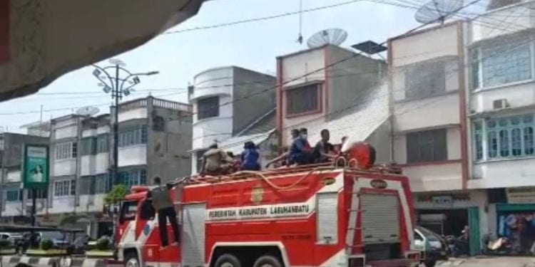 Petugas menyemprotkan desinfektan di jalan Kota Rantauprapat dengan menggunakan mobil Damkar