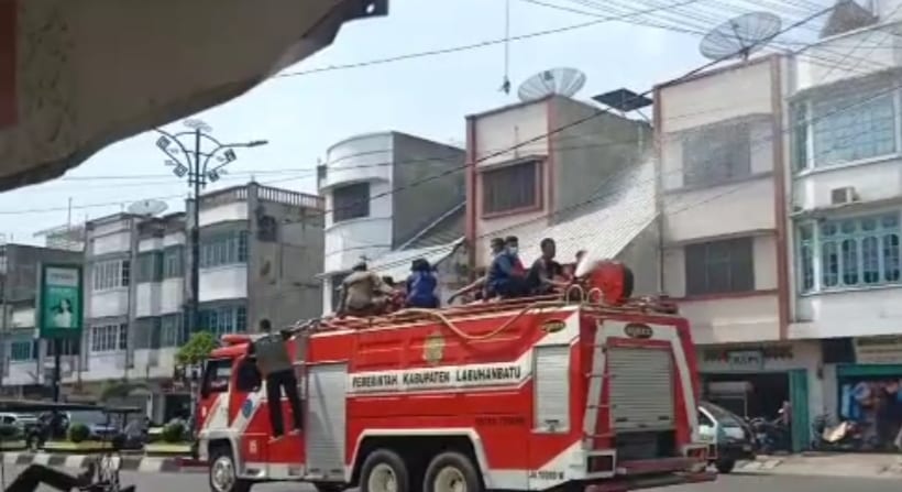 Petugas menyemprotkan desinfektan di jalan Kota Rantauprapat dengan menggunakan mobil Damkar