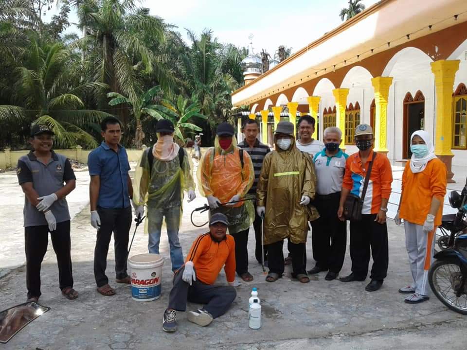 Petugas di salahsatu desa usai melakukan penyemprotan disenfektan.