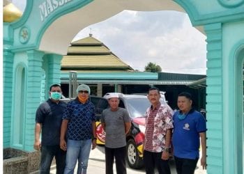 Ketua Karang Taruna Kabupaten Labuhanbatu Aswin saat ikut memantau petugas menyemprotkan desinfektan di salah satu rumah ibadah
