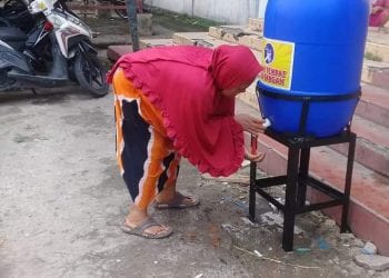 Warga mencuci tangan di depan salahsatu pintu masuk ke Pasar Gelugur Rantauprapat.