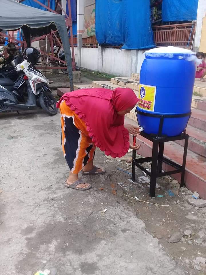 Warga mencuci tangan di depan salahsatu pintu masuk ke Pasar Gelugur Rantauprapat.