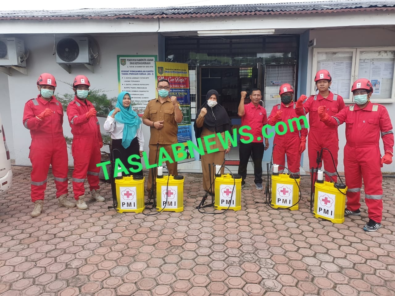 Pegawai Disnaker dan petugas PMI Asahan yang melakukan penyemprotan cairan desinfektan di kantor Disnaker Asahan.