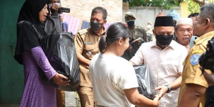 Bupati Labuhanbatu H Andi Suhaimi Dalimunthe ST MT saat memberikan paket Sembako kepada Warga.