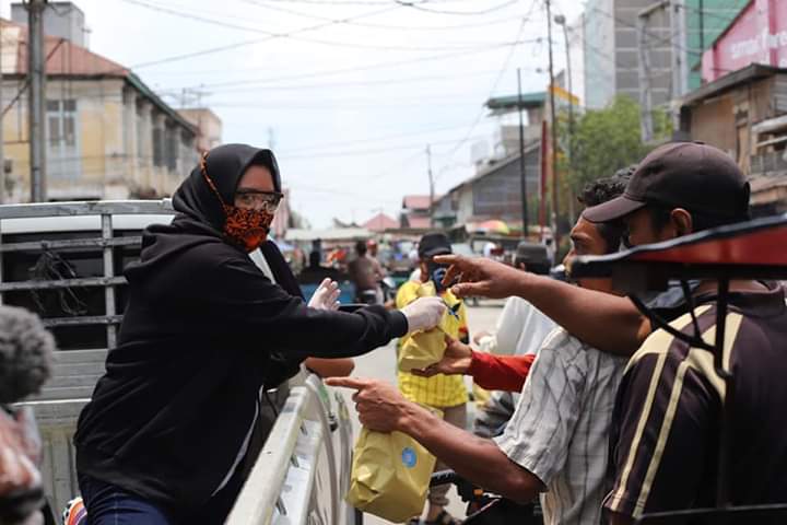 Ketua TP-PKK Tanjungbalai Hj. Sri Silvisa Novita M Syahrial bersama pengurus PKK Tanjungbalai membagikan makan siang gratis untuk warga.