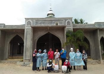 Petugas dari PMI Labuhanbatu saat berada di salah satu rumah ibadah setelah menyemprotkan desinfektan.