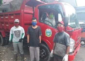 Petugas pengangkut sampah dan supir mengenakan masker