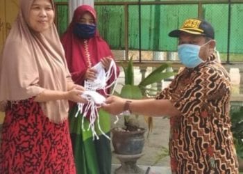 Kades Kampung Padang saat membagikan masker ke warga.