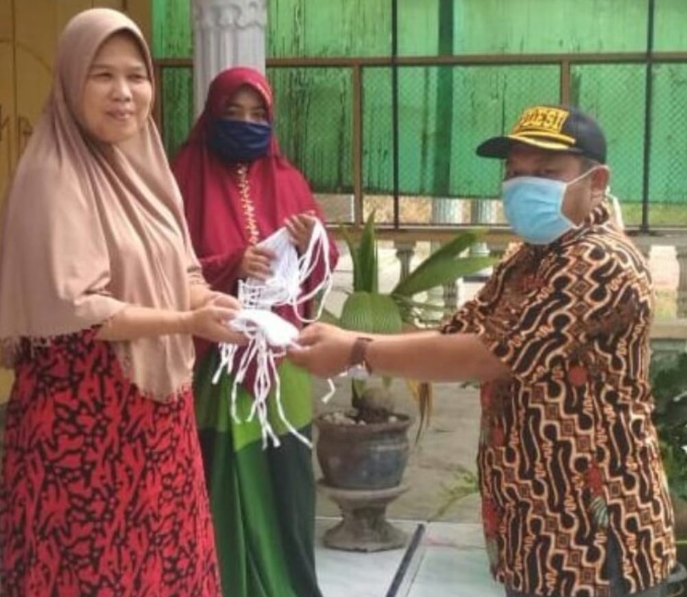 Kades Kampung Padang saat membagikan masker ke warga.