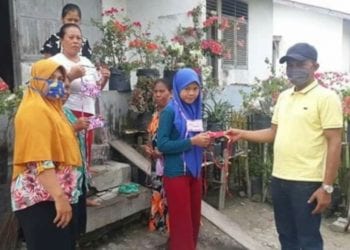 Kades Negeri lama Supriono saat memberikan masker kepada sejumlah warga.