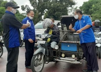 Pengurus Partai NasDem Labuhanbatu saat membagikan masker kepada warga yang melintas.