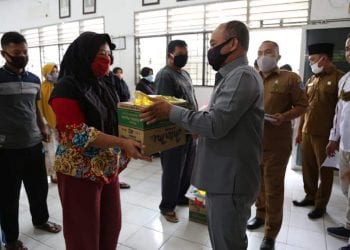 Bupati Labuhanbatu H Andi Suhaimi Dalimunthe ST MT saat menyerahkan bantuan kepada masyarakat.