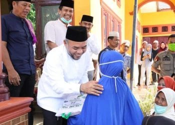 Bupati Labuhanbatu H Andi Suhaimi Dalimunthe ST MT saat memberikan paket sembako kepada salahseorang warga setempat.
