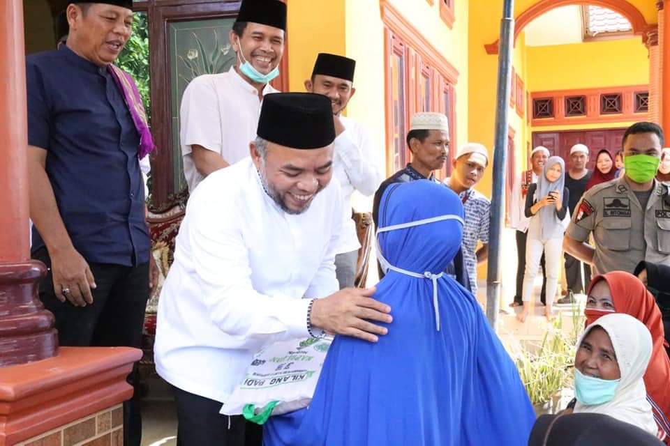 Bupati Labuhanbatu H Andi Suhaimi Dalimunthe ST MT saat memberikan paket sembako kepada salahseorang warga setempat.
