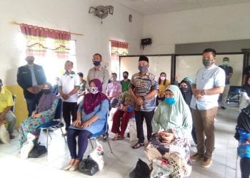 Warga saat mengantri saat membeli sembako di kantor Camat Rantau Utara.