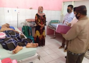Camat Rantau Utara Turing Ritonga bersama dengan pihak Baznas saat menjenguk warga yang diduga mengalami penyakit tumor di RSUD Rantauprapat.