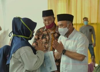 Bupati Labuhanbatu H Andi Suhaimi Dalimunthe ST MT saat menyalurkan bantuan kepada masyarakat.