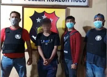 (Ricad Silaban/taslabnews) Pelaku (nomor 2 dari kiri) diapit Kanit Reskrim Ipda Yuna H. Gultom dan anggota