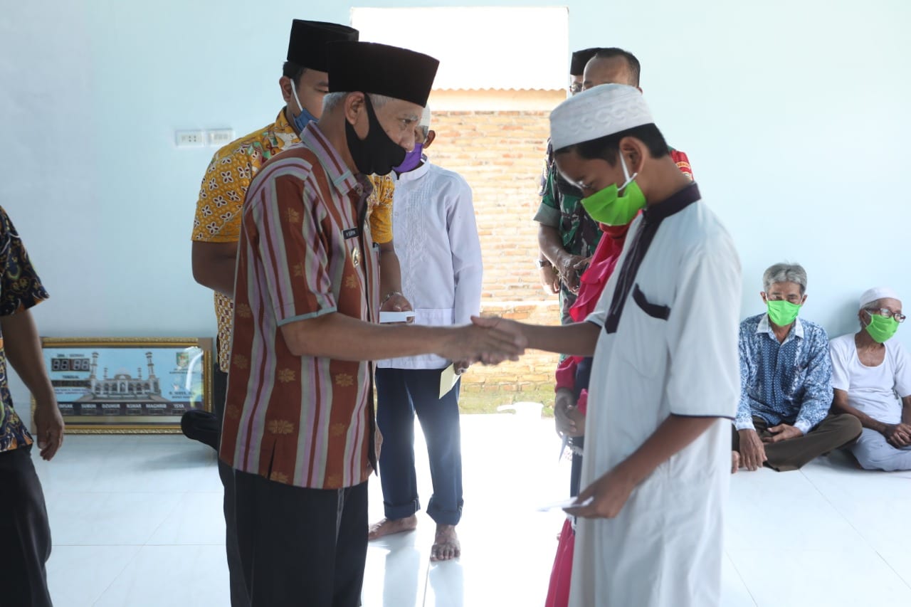 Bupati Asahan Surya saat memberikan bantuan di acara safari Ramadan khusus.