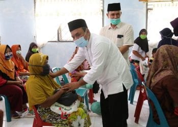 Bupati Labuhanbatu H Andi Suhaimi Dalimunthe ST MT saat memberikan bantuan Sembako kepada warga.