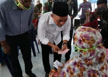 Bupati Labuhanbatu H Andi Suhaimi Dalimunthe ST MT saat menyalurkan bantuan kepada masyarakat.