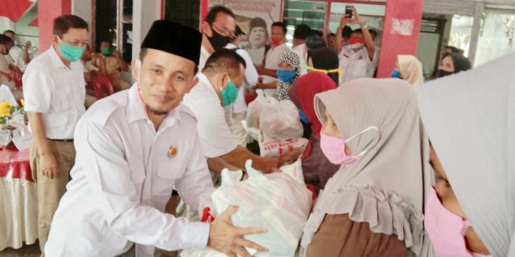 Ketua Partai Gerindra Labuhanbatu, Abdul Karim Hasibuan saat menyerahkan paket sembako kepada warga terdampak Covid-19.