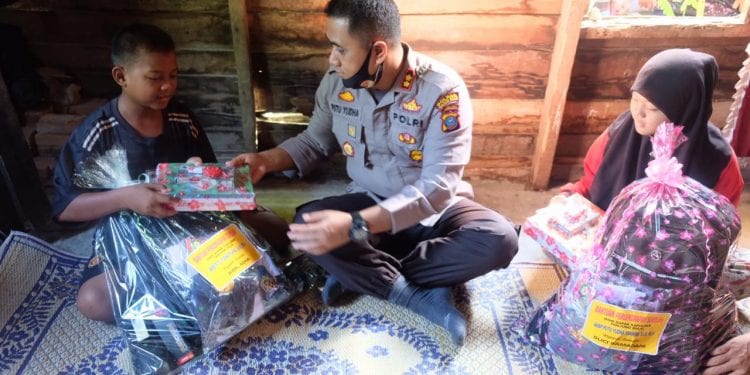 Kapolres Tanjungbalai, AKBP Putu Yudha Prawira SIK MH didampingi PJU Polres Tanjungbalai saat memberikan santunan kepada 2 anak yatim piatu, Suci Ramadani dan Aidil Adha.