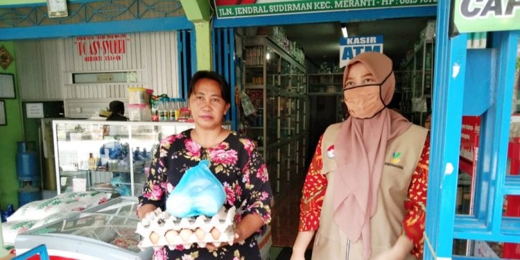 Pendamping penyalur bantuan PKH, Suci (kanan) saat memantau pembagian bantuan.