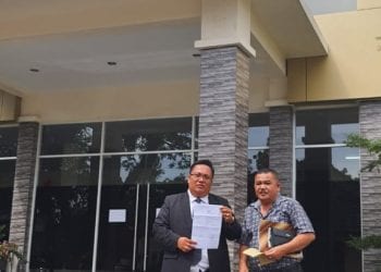 Ir H Muhammad Yusuf Siagian didampingi Kuasa Hukum Akhyar Idris Sagala SH memperlihatkan surat tanda terima laporan usai keluar dari gedung SPK Polda Sumut