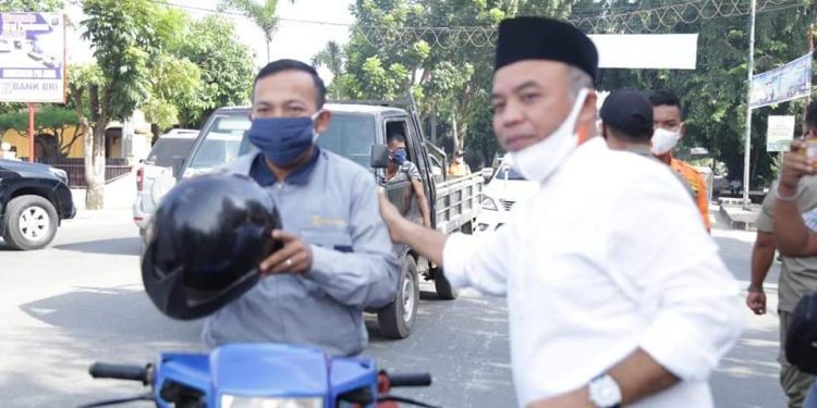 Bupati Labuhanbatu H Andi Suhaimi Dalimunthe ST MT saat membagikan masker kepada warga.