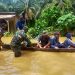 (Richad Silaban/taslabnews) Petugas Polsek Kualuh Hulu dan Koramil 01/AK mengevakuasi warga yang rumahnya terendam banjir