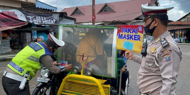 Suasana sosialisasi kebiasaan hidup sehat dengan menempelkan stiker bertuliskan 'Ayo Pakai Masker'.