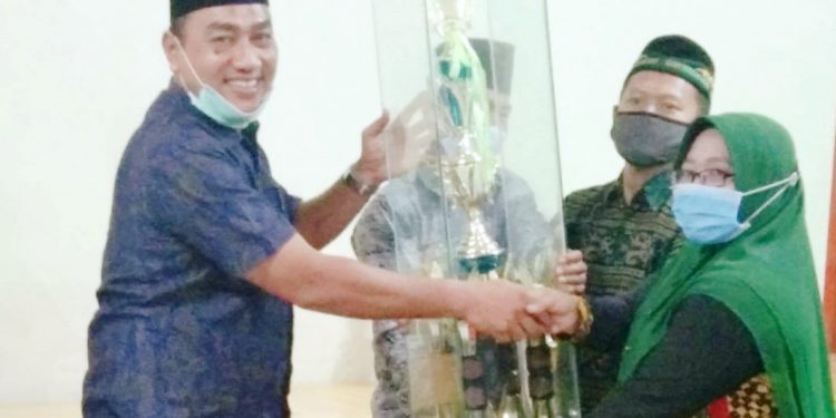 Camat Meranti, Khualid Armansyah menyerahkan piala juara umum.
