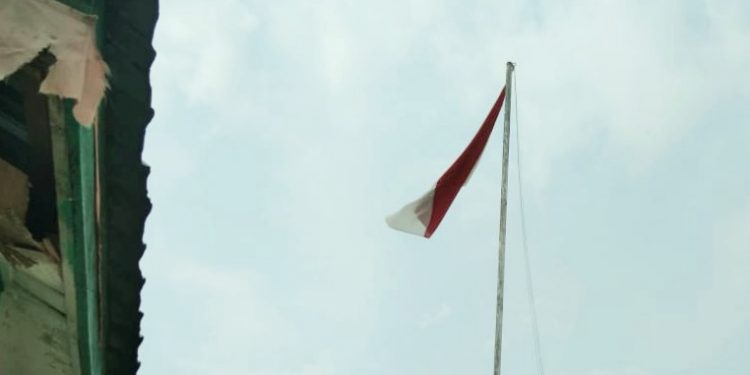 Kondisi bendera Merah Putih yang berkibar hanya dengan satu tali bendera yang terikat.
foto/teks: edi surya