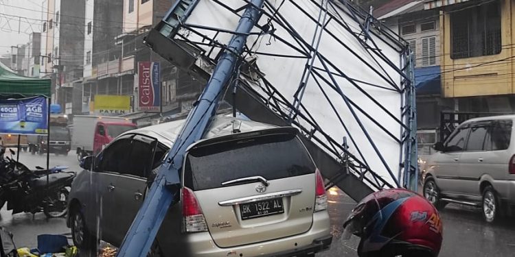Mobil Kijang Innova BK1522 AL ringsek setelah tertimpa papan reklame di Jalinsum Jenderal Sudirman, Aek Kanopan, Labura.
foto/teks: richard silaban
