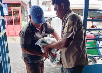 Sekretaris PD IWO Asahan-BatubaraKhairul Anhar Harahap SH saat menyalurkan bantuan beras pada warga