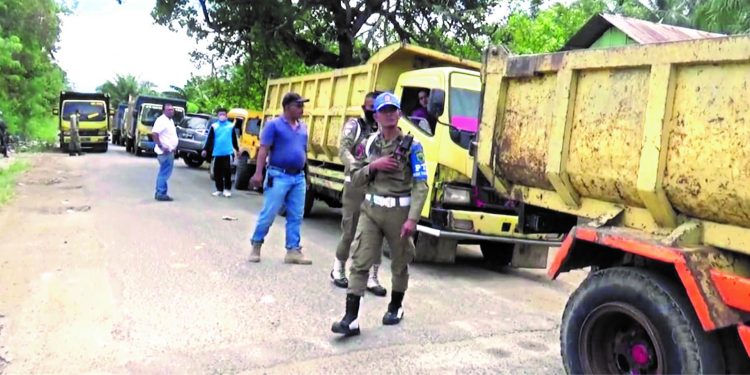 Petugas Satpol PP Pemkab Paluta memeriksa surat tanda bayar pajak kepada supir yang membawa hasil Galian C di Jalan Lintas Sibuhuan-Batang Onang, Paluta.
