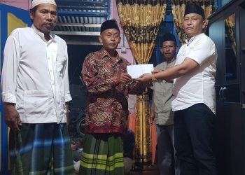 Ketua MOI Labuhanbatu Syaiful Bahri Ritonga (baju putih) saat memberikan bantuan kepada Perwiritan Al-Ikhlas.