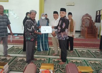 Kabag Keuangan Sekretariat DPRD Labuhanbatu Parulian Ritonga saat menyerahkan bantuan kepada pengurus mesjid Jami'Amaliyah