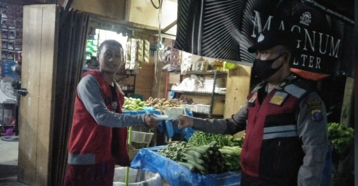 Personel Polsek Bandar Pulau Bagikan Masker Kepada Masyarakat di Pajak Pagi Desa Aek Songsongan