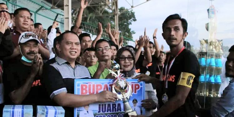 Bupati Labuhanbatu H Erik Adtrada Ritonga saat memberikan hadiah tropy kepada tim sepakbola Desa Kampung Baru, Kecamatan Bilah Barat.