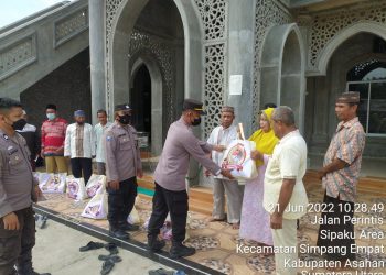 Personel Polsek Simpang Empat Asahan memberikan bansos ke warga.