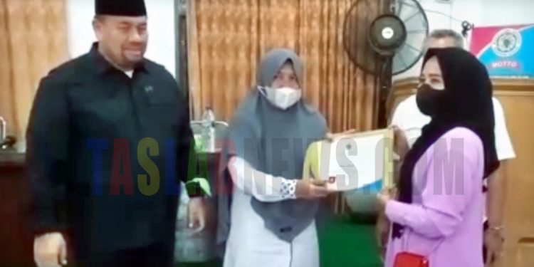 Kepala Disnaker Provsu, Baharuddin Sinaga dan Kepala Disnaker Asahan, Dra Melina Siregar menyerahkan bantuan peralatan usaha kepada wirausahawan baru di Kabupaten Asan.