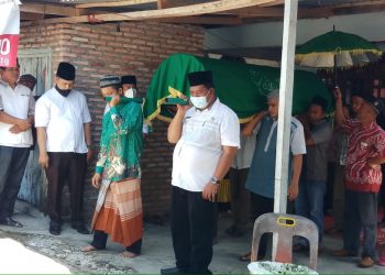 Rustam Efendi Ritonga terlihat saat ikut mengusung jenazah warga Desa Tanjung Harapan untuk dikebumikan.