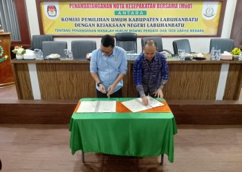 Kajari Labuhanbatu Furkonsyah Lubis SH MH dan Ketua KPU Labuhanbatu Wahyudi SSos terlihat melakukan penandatangan nota kesepakatan bersama.