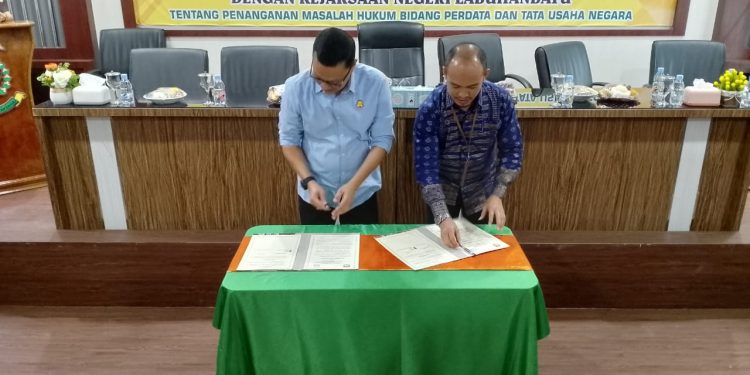 Kajari Labuhanbatu Furkonsyah Lubis SH MH dan Ketua KPU Labuhanbatu Wahyudi SSos terlihat melakukan penandatangan nota kesepakatan bersama.