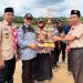 Kamabigus Akhmad Syiroj saat menerima Piala Juara Umum dari Pimpinan Ponpes Darus Sholihin, Ustadz Tholib.