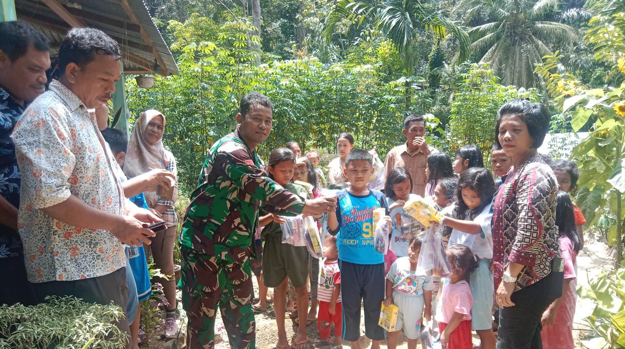 (TASLABNEWS, Rey Simorangkir)Babinsa Koramil 05/Kolang, Praka Armin Simanjuntak bersama Aparatur Desa menyalurkan Makanan Tambahan kepada Balita dan Lansia di Desa Bair, Kabupaten Tapteng. 
